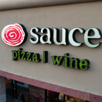sauce pizza and wine franchise logo on building