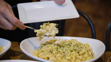Pasta being scooped onto a plate