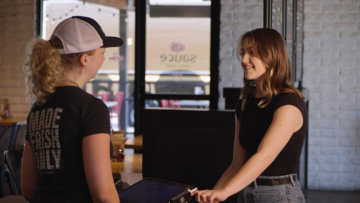 Sauce employee serving a guest